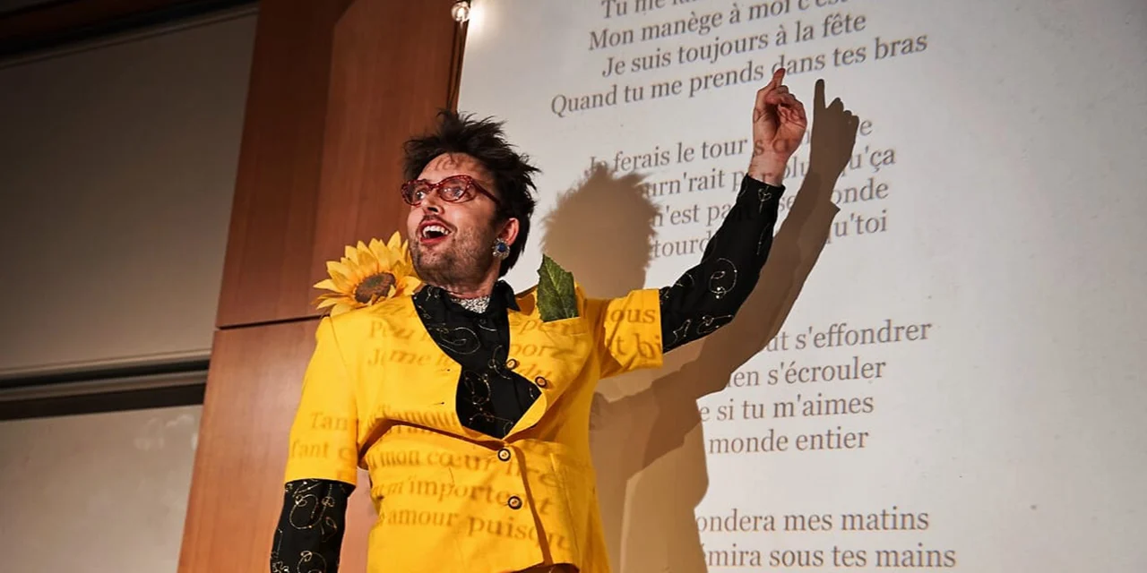 Aurélien Villard habillé en jaune guide le public pour chanter en choeur.