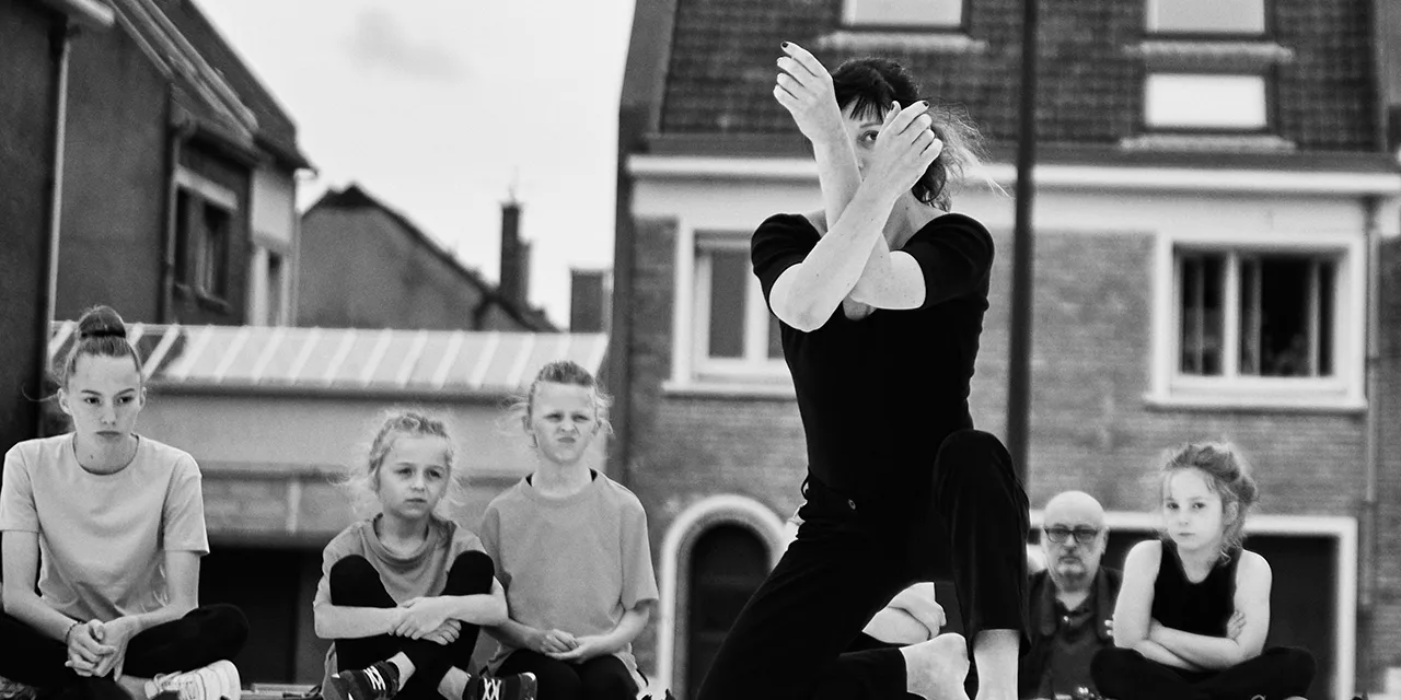 La danseuse Agnès Canova en position accroupie sur scène en plein air