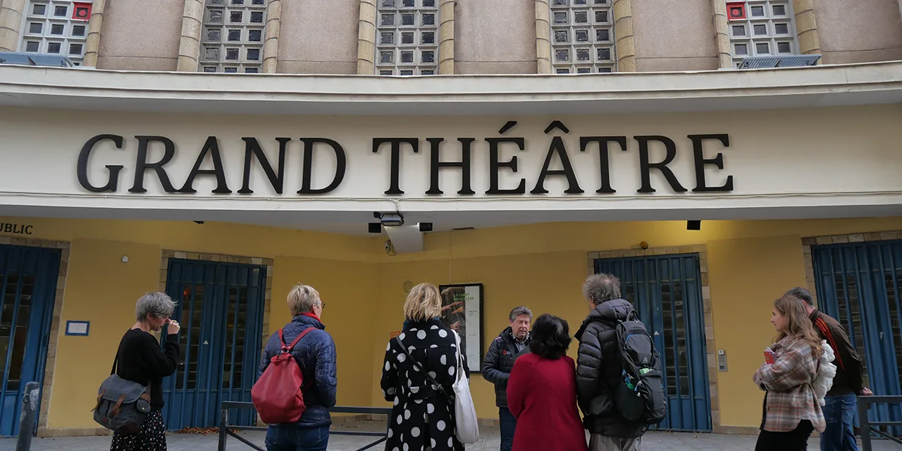 Plusieurs personnes assistant à un visite guidée devant la façade du Grand Théâtre