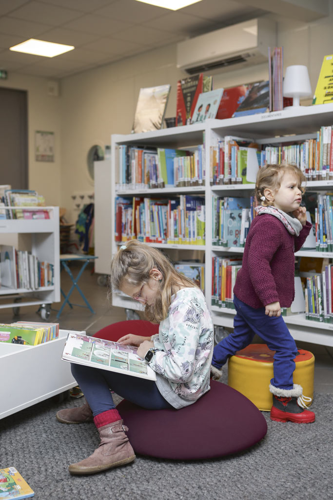 Des enfants lisent dans une bibliothèque.