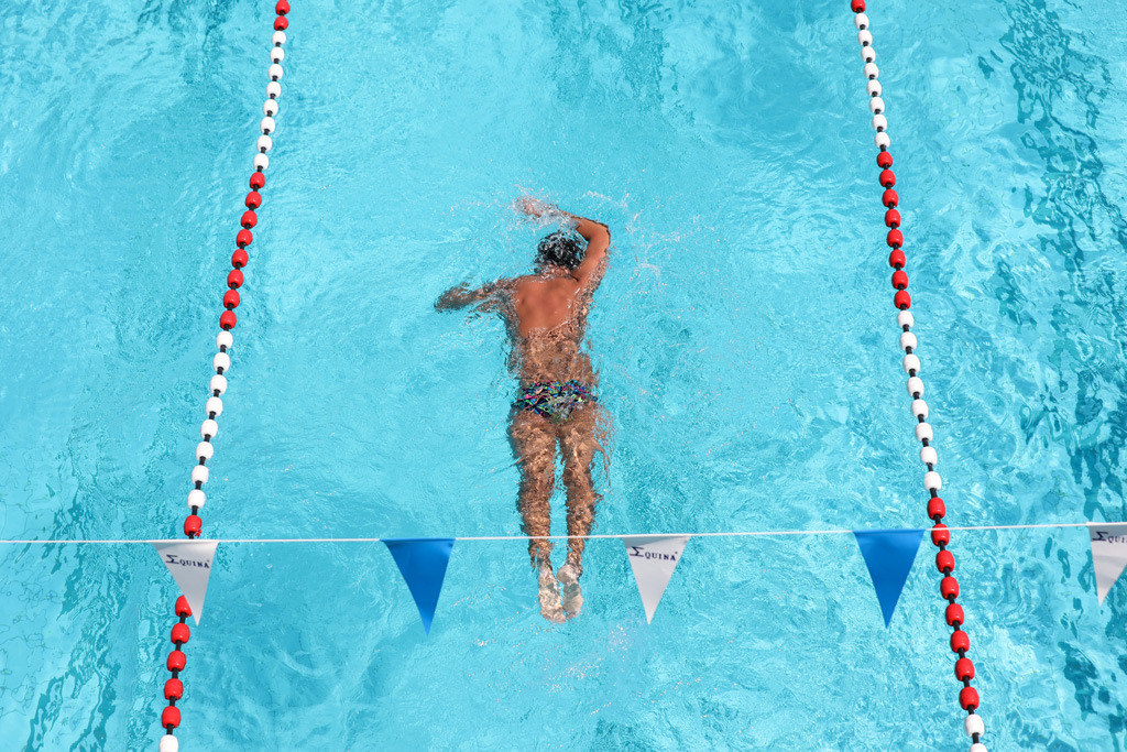 Une nageuse fait des longueurs dans une piscine. 