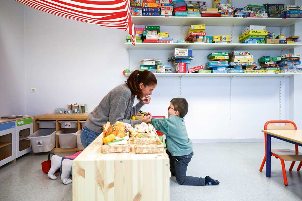 Un enfant et une adulte jouent à la dinette.