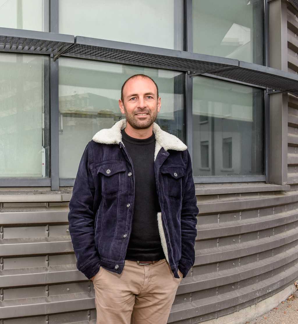 Antoine Gentil pose devant un bâtiment.