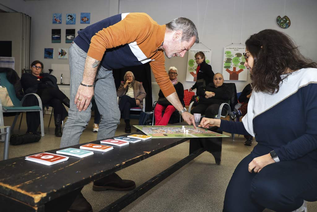 Des personnes jouent à un jeu pédagogique autour de l'énergie.