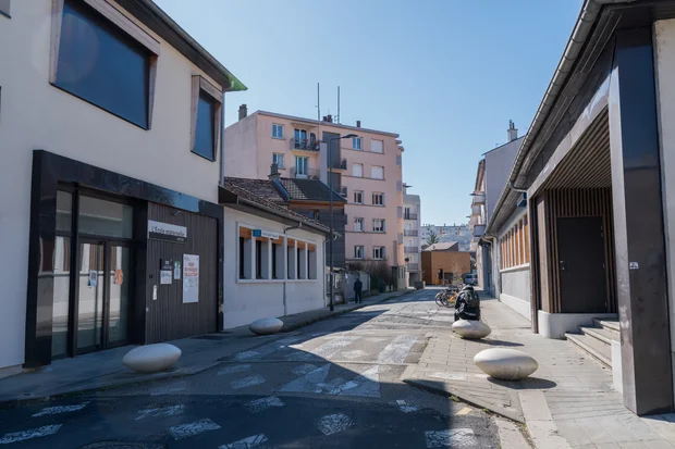 La rue du Drac qui passe devant le Groupe scolaire Ampère. Installation de blocs anti-stationnement.