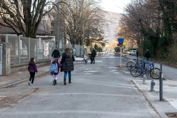 Devant l'école Malherbe, rue Blaise Pascal, une mère de famille accompagne deux filles.