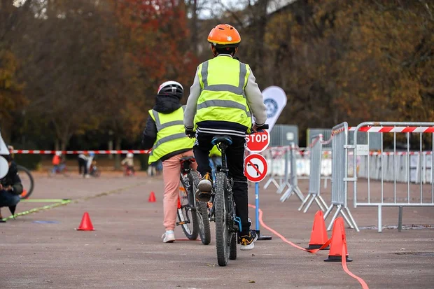 Sur l'anneau de vitesse de Grenoble de jeunes enfants apprennent les principes de circulation à vélo en milieu urbain.