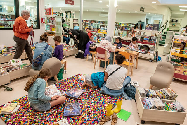 Des enfants lisent des albums dans la bibliothèque.