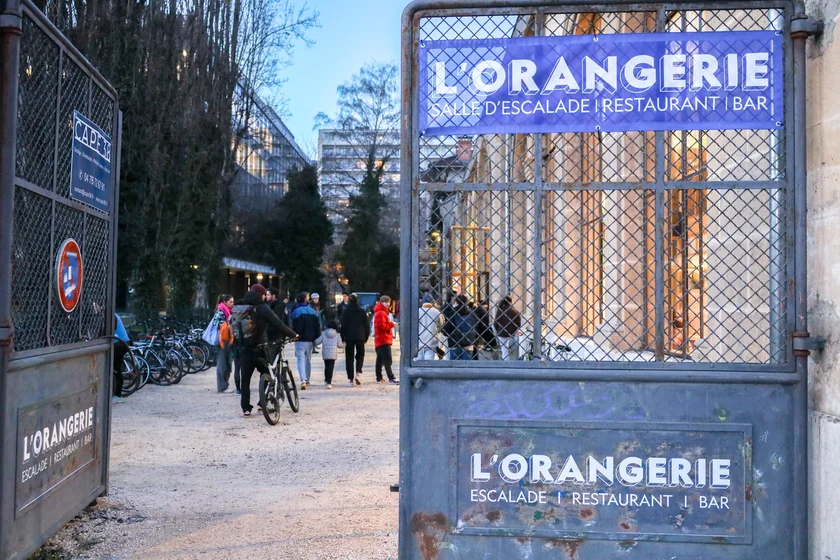 Photo de l'entrée avec le portail de l'orangerie. Panneau "escalalde, restaurant, bar"